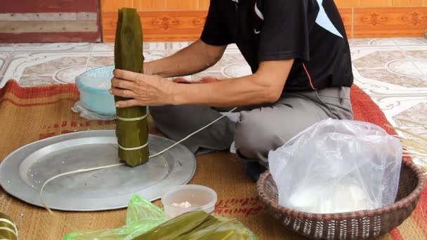 Aziatische vrouw verpakking rijst taart — Stockvideo
